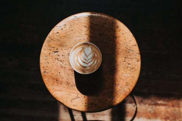 white ceramic cup on brown wooden stool